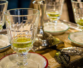 An ornate tray holds three cups with a few ounces of absinthe, a bright green liquid, at La Galerie de l'Absinthe at the Southern Food &amp; Beverage Museum.