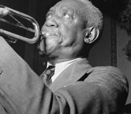 A side view of bunk blowing into his trumpet