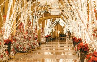 The Roosevelt Hotel Holiday Lobby, with brightly lit trees on either side of the hallway.