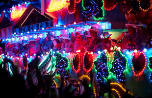 People wear glowing necklaces at the Bacchus Parade in New Orleans