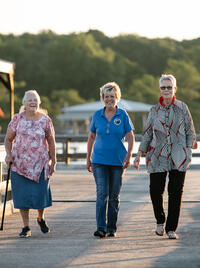 Three tourists stroll a boardwalk in Lake Arthur, Louisiana.